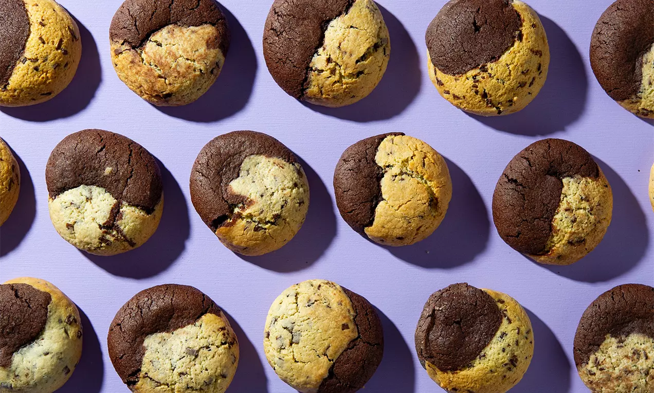 Brookie Cookies met ronde vorm, tweekleurige chocolade- en koekdeeghelften, gebakken tot een zachte textuur op een lichtpaarse ondergrond